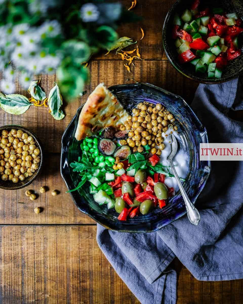 silver spoon on black ceramic bowl with vegetables