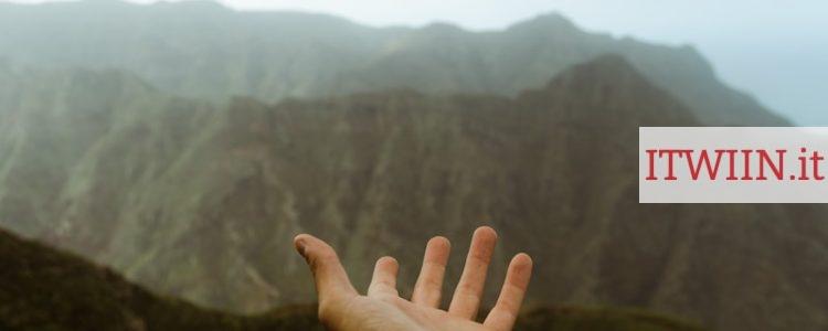 a hand reaching out towards a mountain range