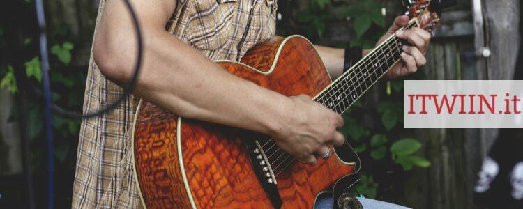 person holding brown guitar outdoor