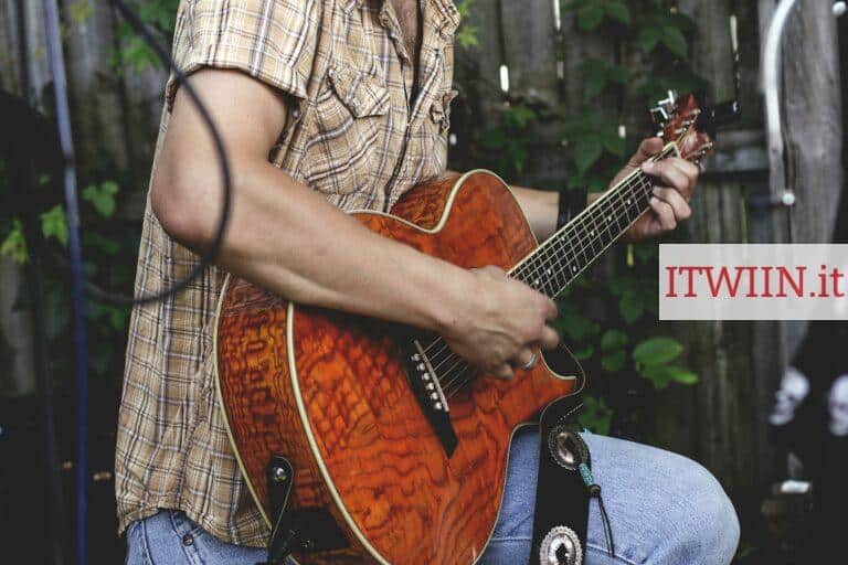 person holding brown guitar outdoor