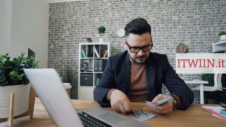 a man sitting at a table in front of a laptop