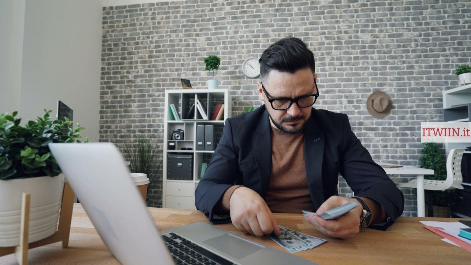 a man sitting at a table in front of a laptop